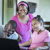 Family members laughing at a computer screen