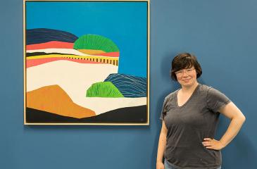 Amanda Webster next to her Painting on bluffs of St. Paul
